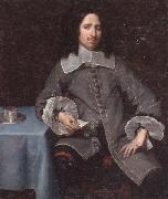 Portrait of a gentleman,three-quarter length,standing beside a table